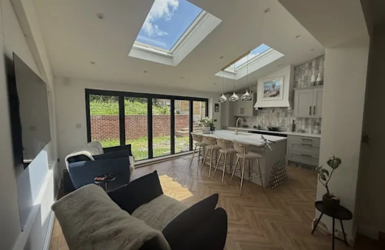 Kitchen and living space with two rooflights and wide dark-framed glazed doors
