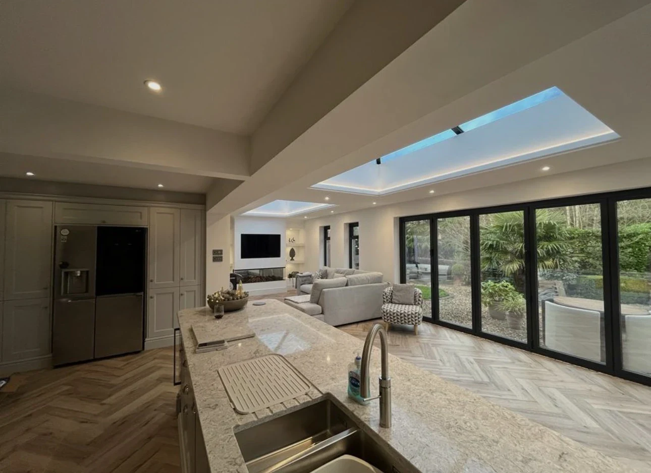 Open-plan kitchen and living interior with rooflights and wide garden glazing