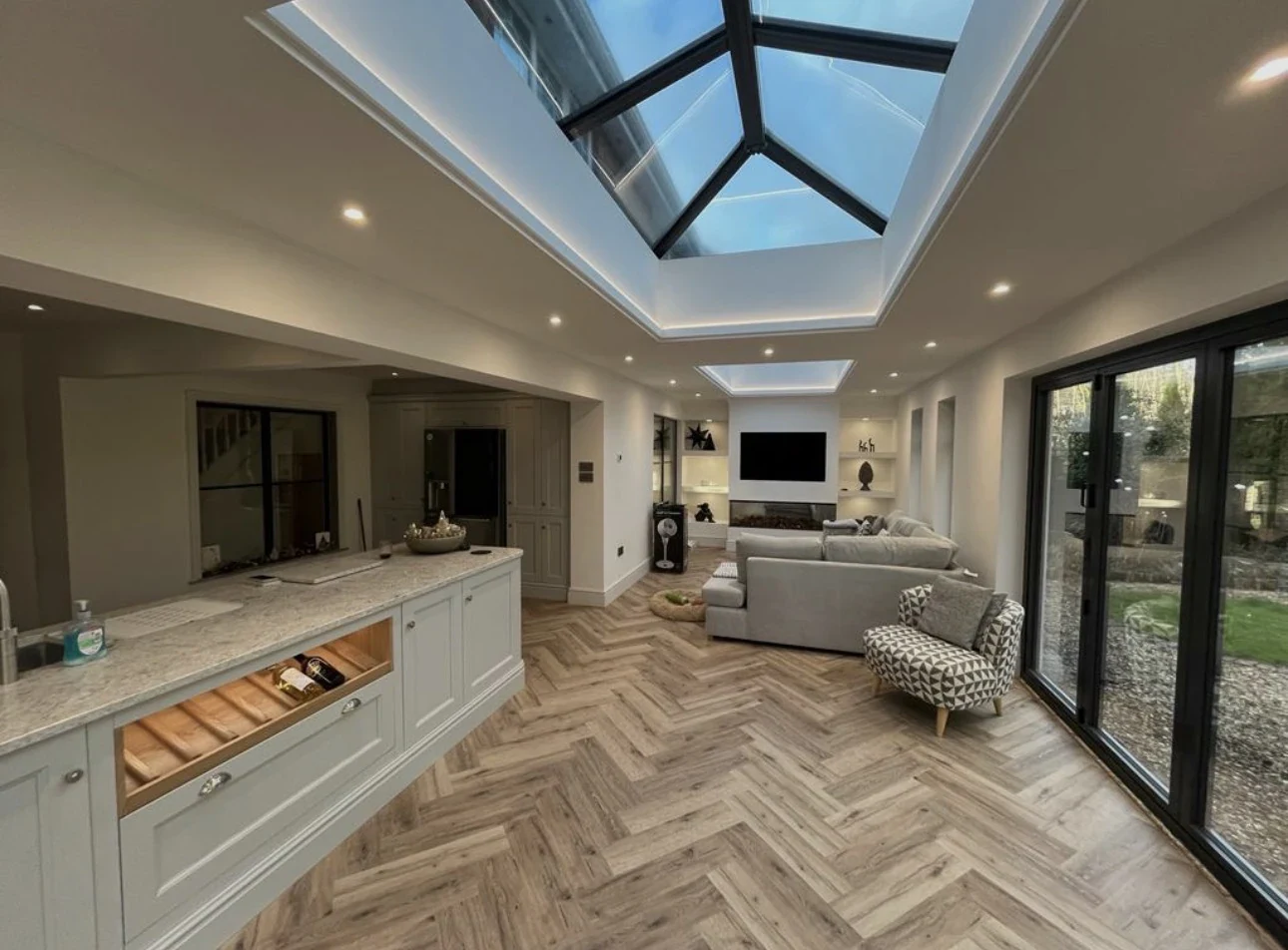Open-plan kitchen and living area beneath large glazed rooflights