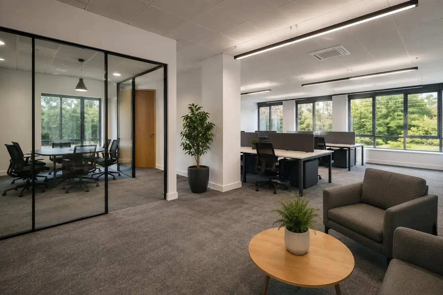 Open office with a glazed meeting room, workstations and linear lighting